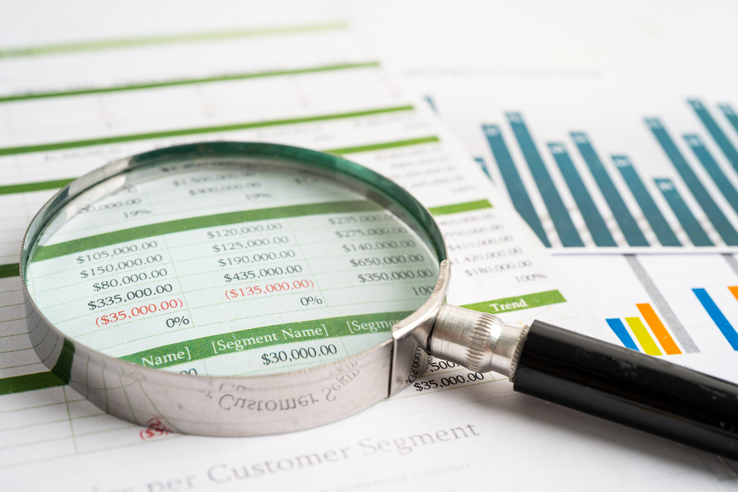 Magnifying glass on charts graphs paper. Financial development,