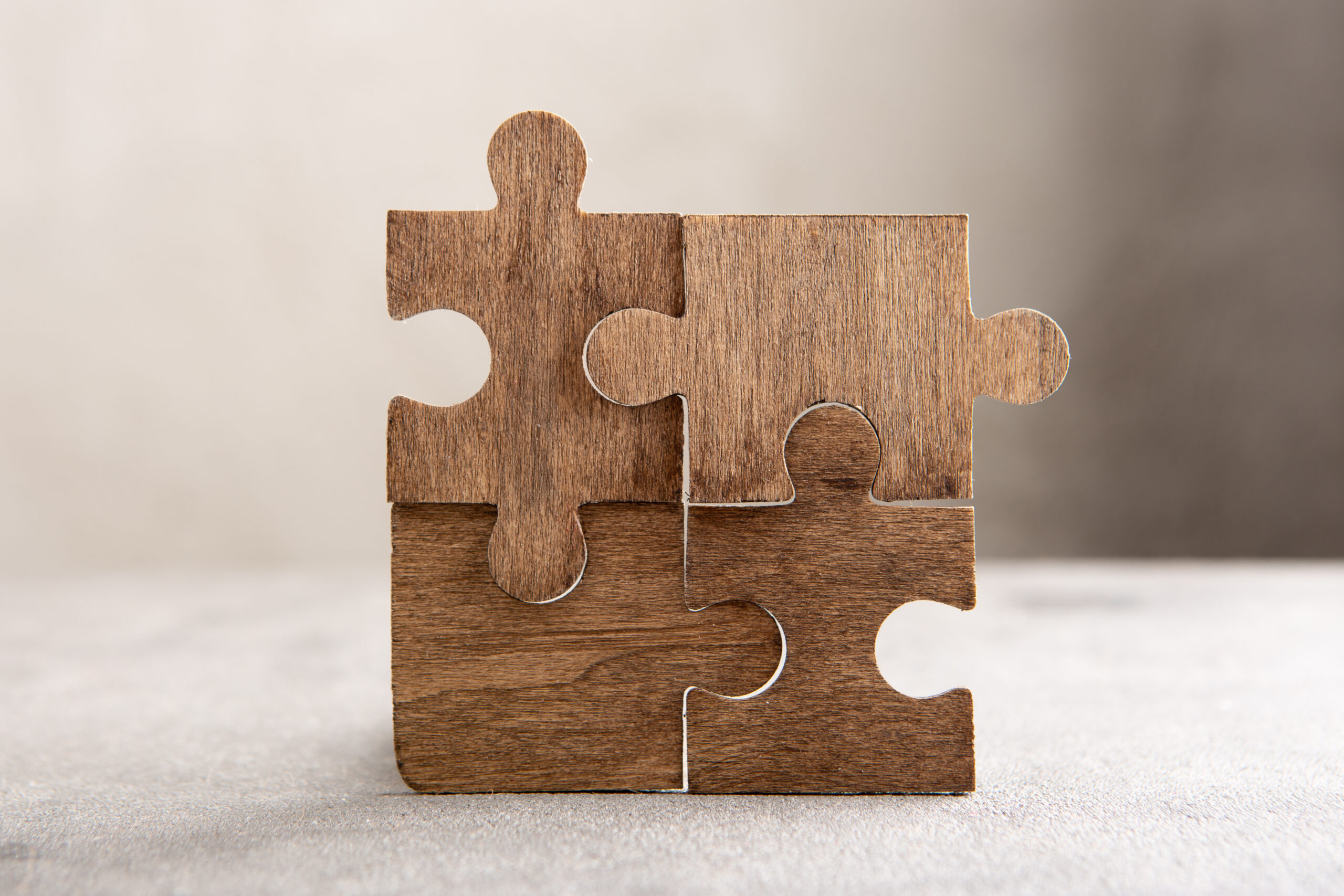 Creative idea and solve the problem concept. Teamwork success strategy - wooden puzzle on the grey background