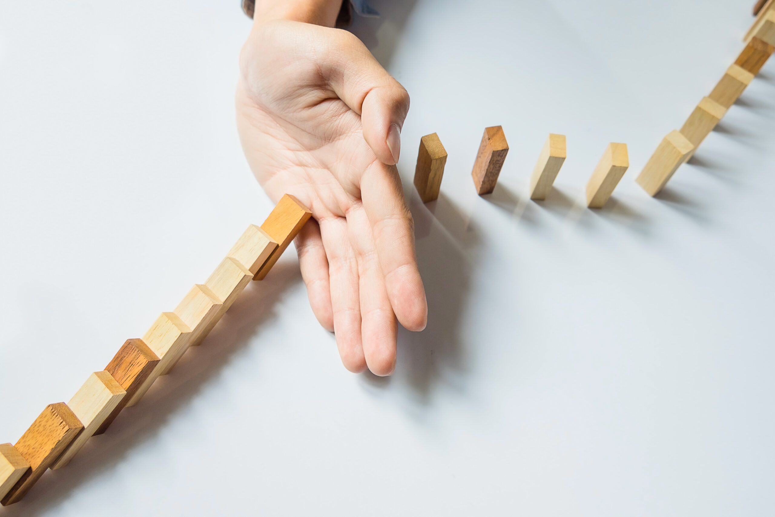 businessman hand stop dominoes continuous toppled or risk with c
