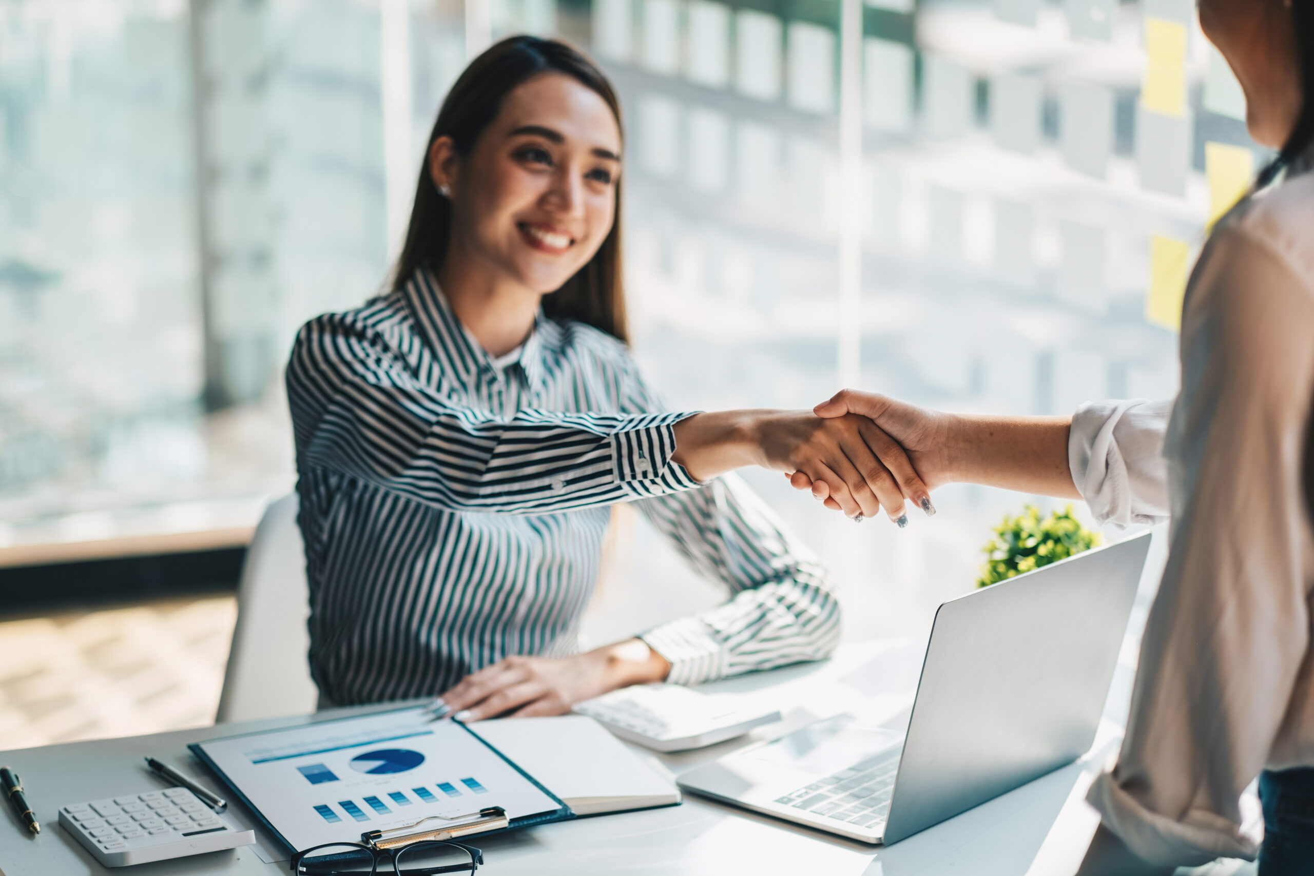 Young asian business people shaking hands in the office. Finishi