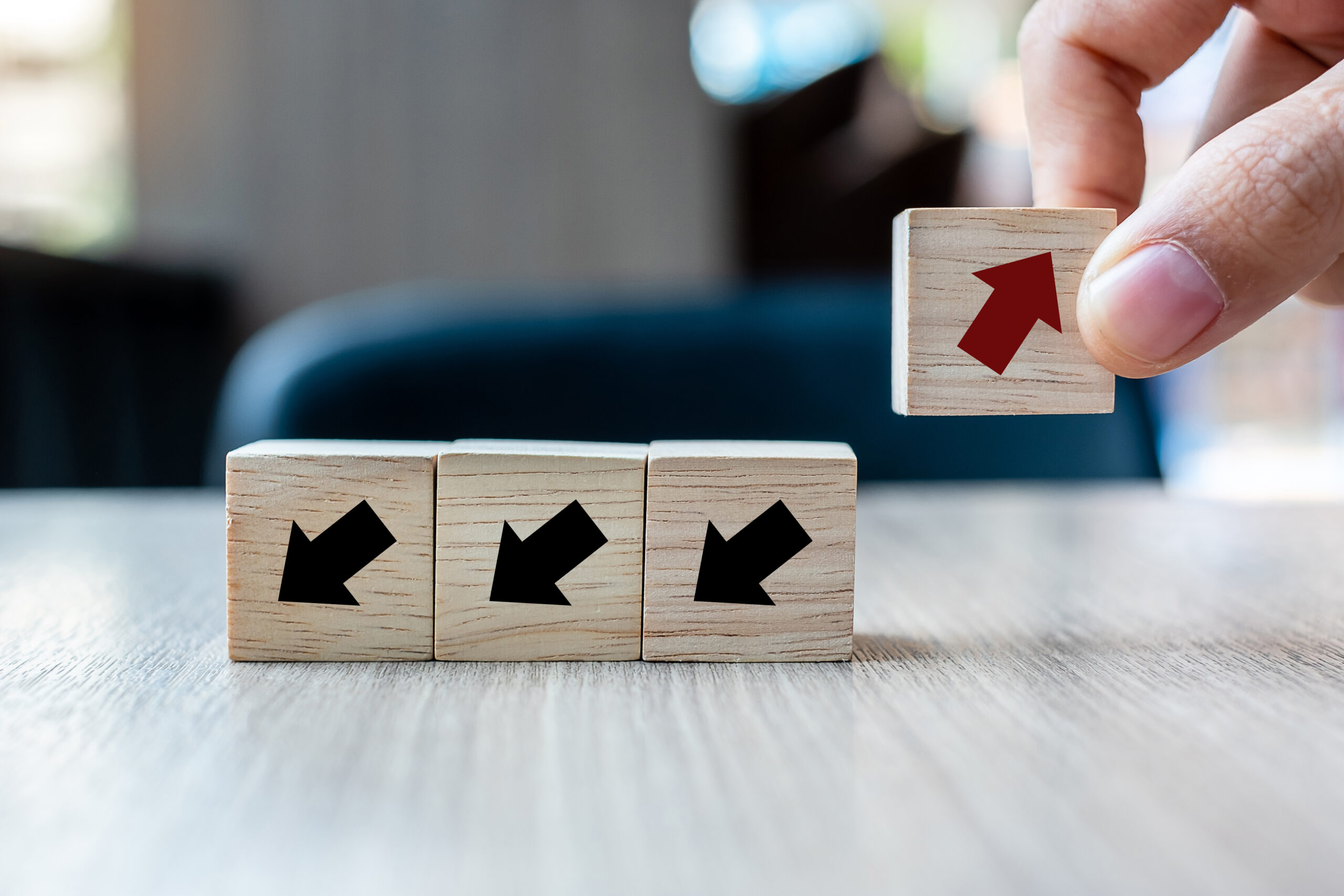 Businessman hand placing or pulling Red arrow wooden block on ta