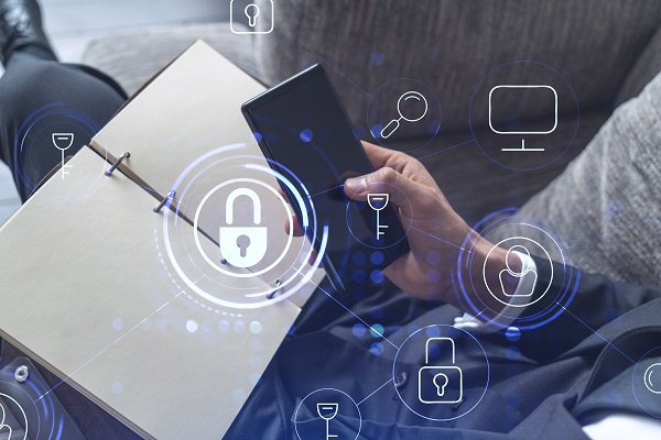 A programmer is browsing the Internet in smart phone to protect a cyber security from hacker attacks and save clients confidential data. Padlock Hologram icons over the typing hands. Formal wear.