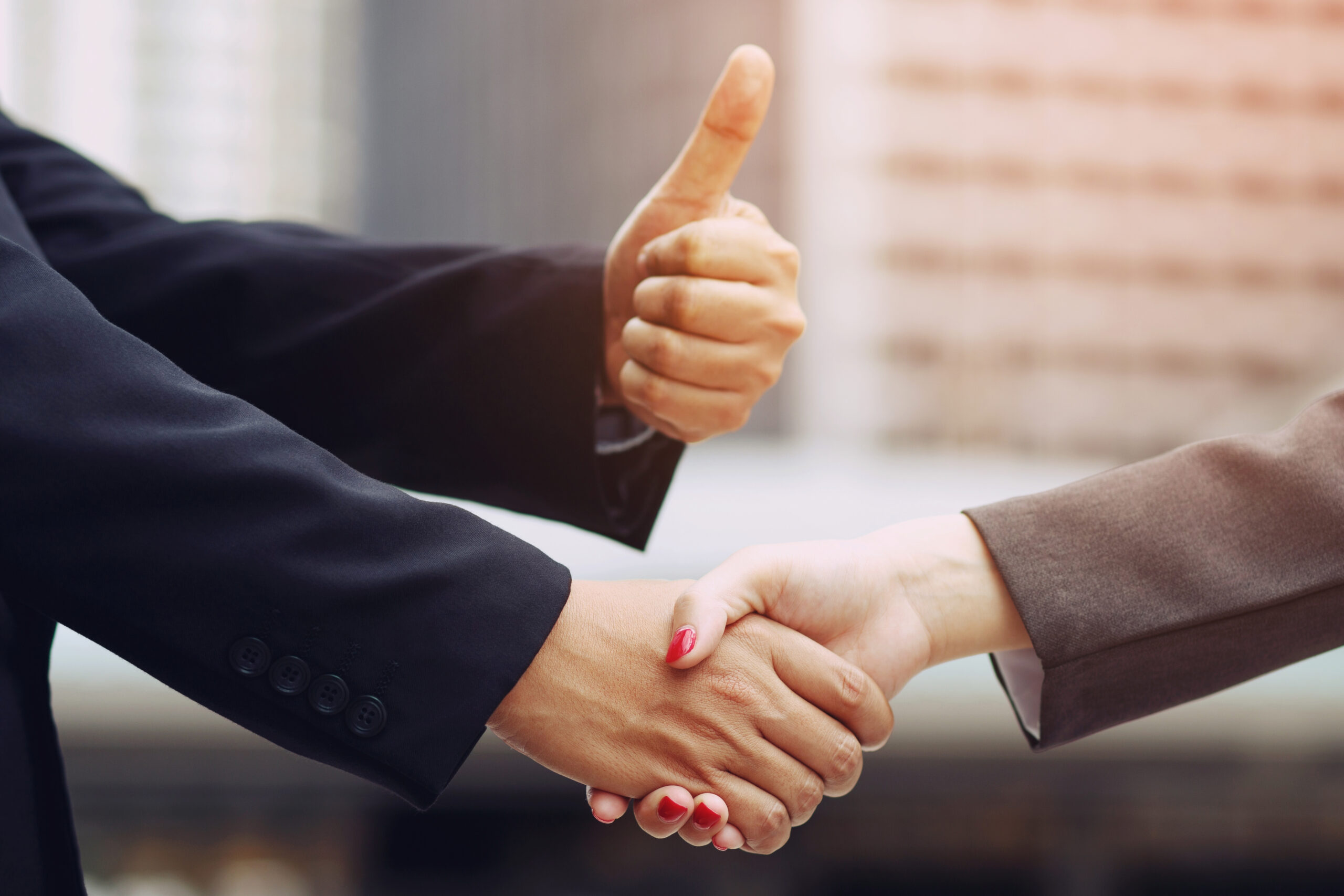 Closeup of a businessman hand shake businesswoman between two co
